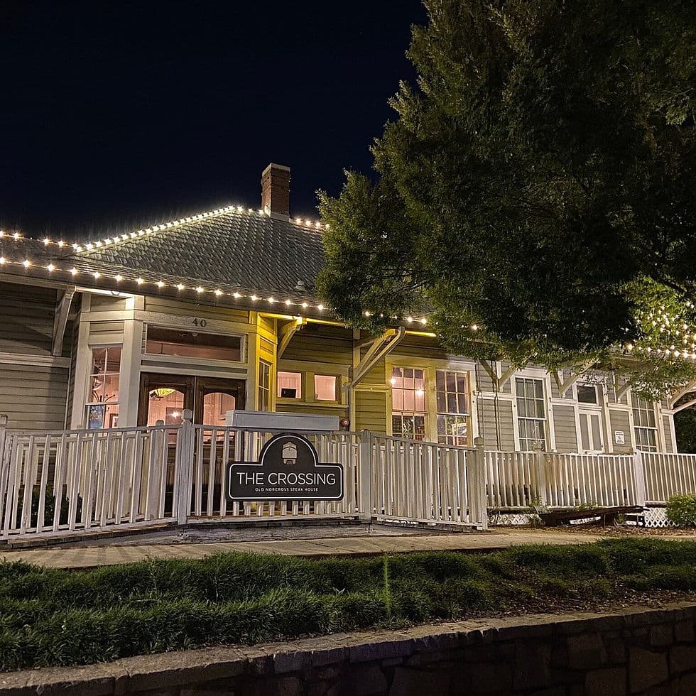 The lit porch and sign of Rathburn Steakhouse in a restored house at 40 S Peachtree Street